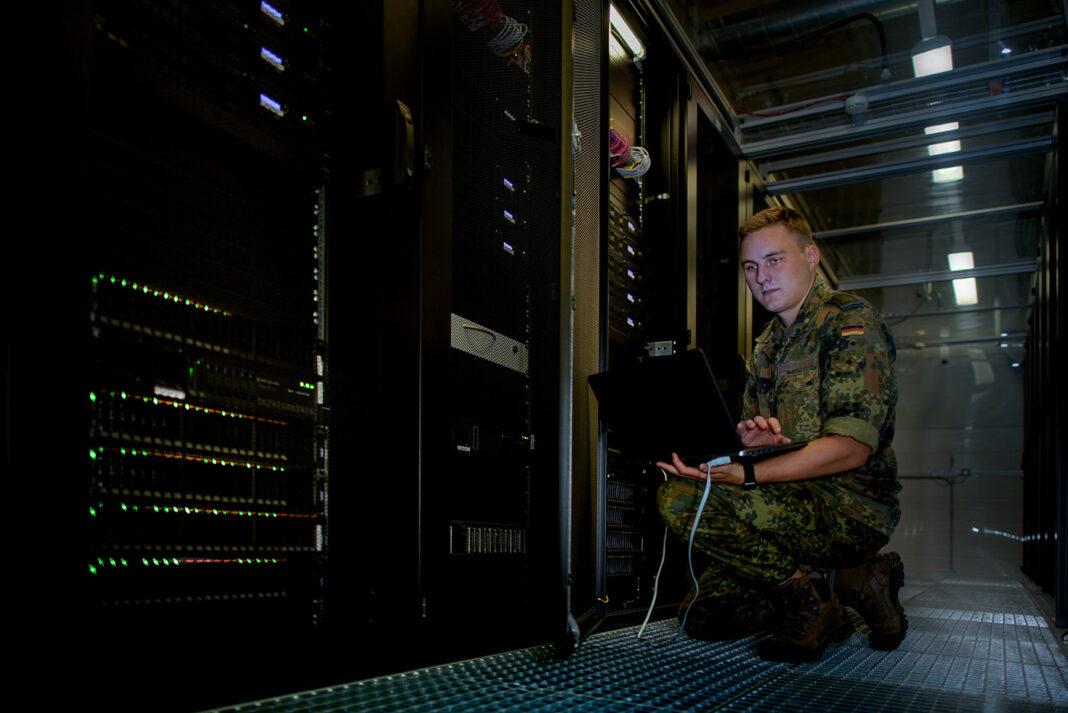 Ein Stabsunteroffizier arbeitet in einem Serverraum – ©Bundeswehr/Grüterich